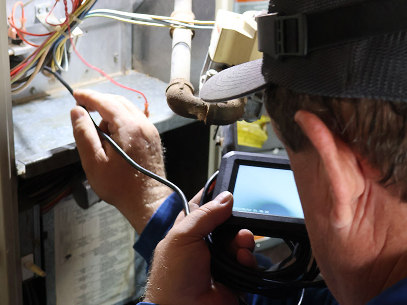 Technician repairing a furnace Technician repairing a furnace